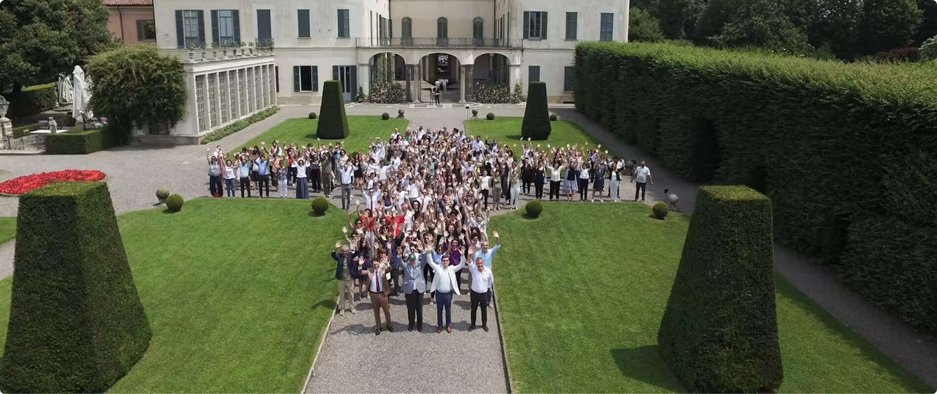 Gruppo di visitatori nel giardino di una villa.