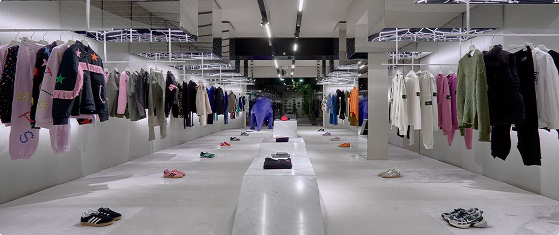 Interno del negozio LuisaViaRoma con esposizione di abiti e calzature.